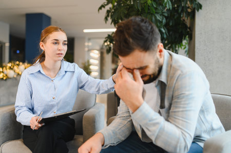 Psychologist offering support and empathy to a distressed male patient in a counseling session. Prioritizing mental health and therapyの写真素材