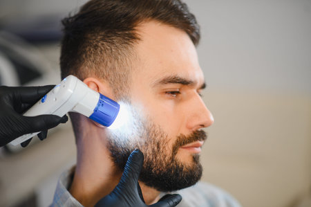 Dermatologist examining patient's beard and facial skin with a dermatoscope. Professional healthcare...