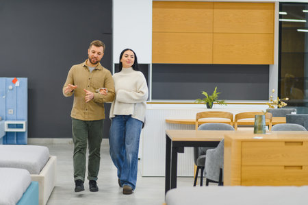 Couple walking through a modern furniture showroom, selecting new pieces for their home and discussing interior design optionsの写真素材