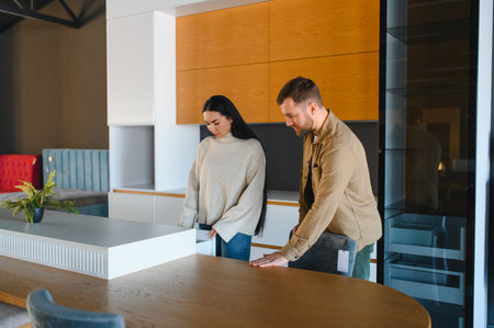 Young couple exploring furniture and home decor in a showroom, looking at kitchen cabinets and dining tablesの写真素材
