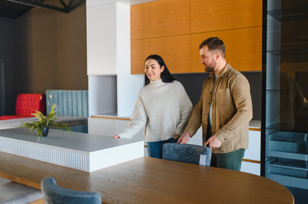 Young couple exploring kitchen showroom, choosing new furniture and discussing home interior design. Planning a modern remodelの写真素材