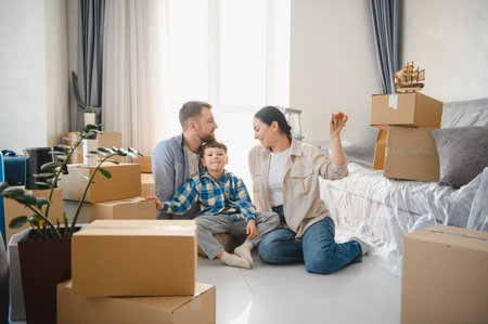 Happy family unpacking cardboard boxes in a new apartment, joyful over fresh start and real estate...