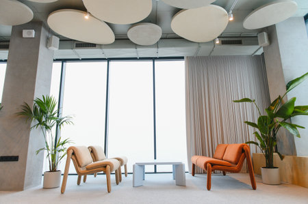 Contemporary lounge area featuring stylish armchairs, minimalist coffee table, and large window in a...