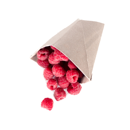ripe raspberries scattered from a package isolatedの写真素材