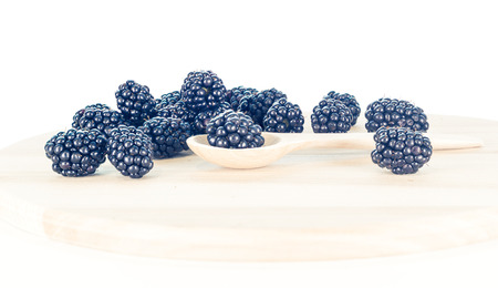 Blackberries on wooden background with wooden spoonの写真素材