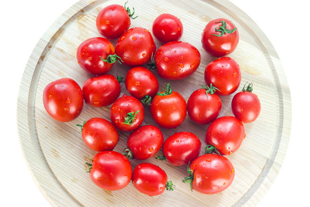group of red ripe tomatoes on a wooden boardの写真素材