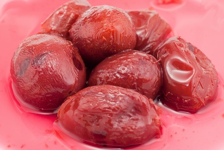 pickled plums with red  juice bakcgroundの写真素材