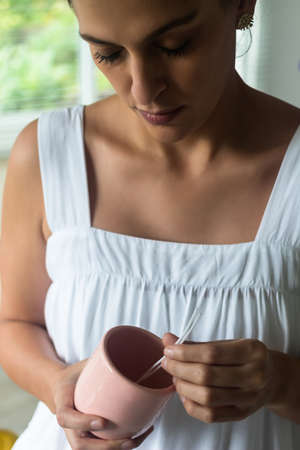 latina woman looking at a homemade candle in process. DIY