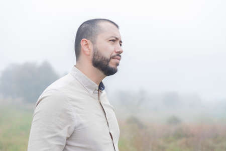 bearded latino man standing in the farm on a cloudy dayの写真素材