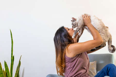 young latina holding and kissing her cat