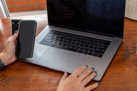 Closeup of a workplace on a desk in an office laptop and mobile phone on table