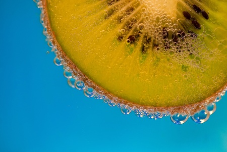Slice of kiwi in sparkling water.の写真素材