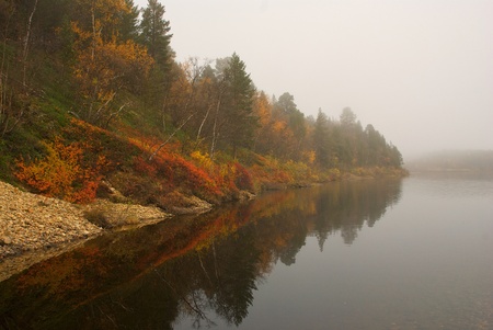 Fall colors reflected from calm lake.