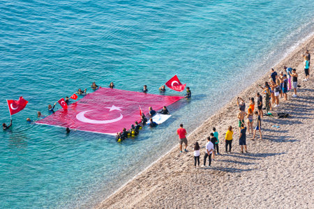 Divers celebrate Republic Day by opening the big Turkish flag on the Konyaalti beach of Antalya. October 2019のeditorial素材