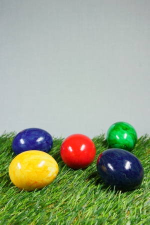 colorful easter eggs on a lawn of artificial greenの写真素材