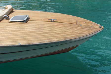 Prow of a motorboat or speedboat with a wood finish moored in a harbor in sheltered water, high...
