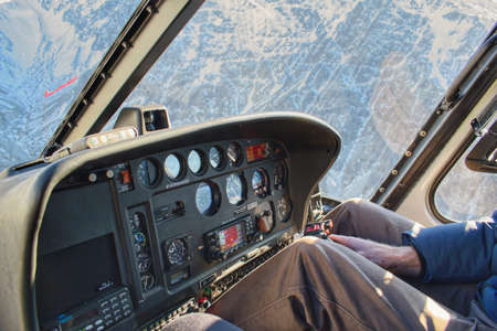 Helicopter cockpit during flight in mountainous area close to terrain