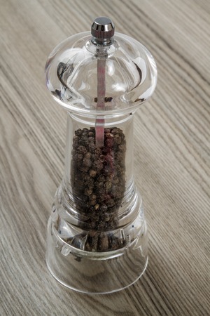 View of a pepper mill on a wooden background