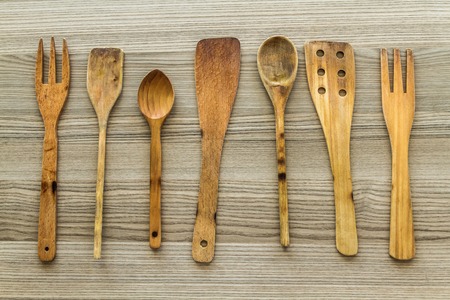 Kitchen wooden utensil of scapula, spoon and fork on wooden table