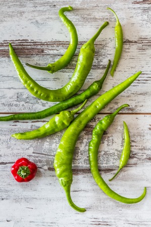 Red hot cherry pepper and green peppers over white wooden backgroundの写真素材