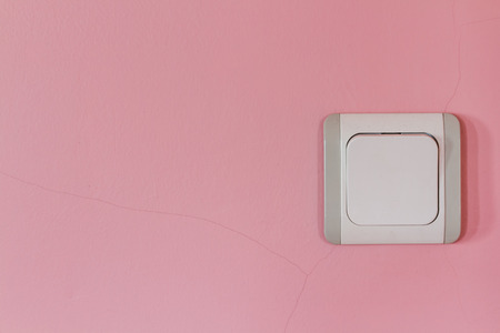 Old white and gray electricity switch on pink wallの写真素材