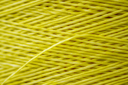 Close up of a spool of synthetic green thread