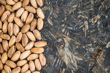 Pistachio nuts as texture or background on blue wooden background