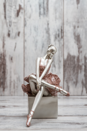 Ballerina figure with pink dress on white wooden backgroundの写真素材