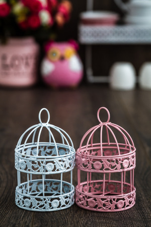 Pink and blue wrought iron candle holders on wooden backgroundの写真素材