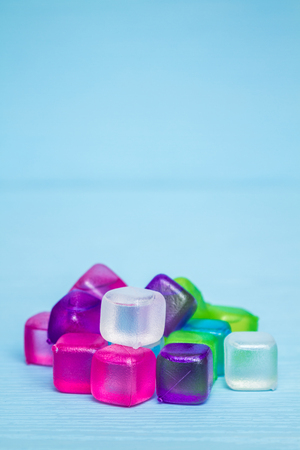 Colorful plastic ice cubes on blue backgroundの写真素材