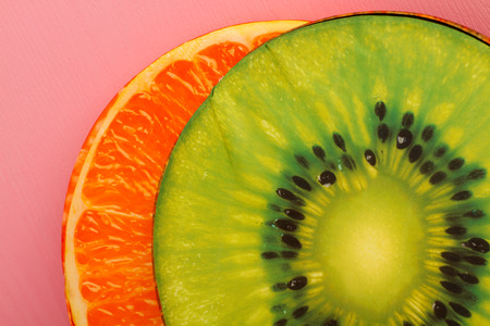 Decorative pillows designed as Kiwi and Orange on pink backgroundの写真素材