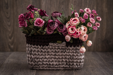 Decorative knitted baskets with ribbons on wooden backgroundの写真素材