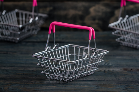 Miniature shopping baskets on blue wooden backgroundの写真素材