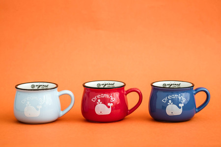 Creative, cute coffee mugs on orange backgroundのeditorial素材