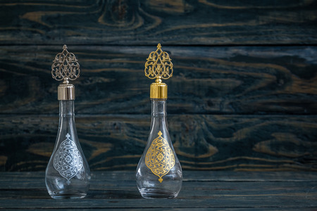 Glass cologne bottle with Ottoman pattern and metal lid on blue backgroundの写真素材