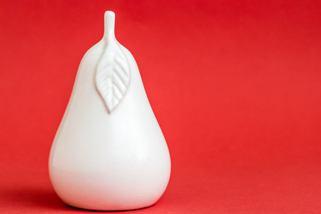 Decorative colorful ceramic pear shaped trinket on red backgroundの写真素材
