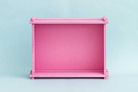 Pink wooden fruit and vegetable box on blue background
