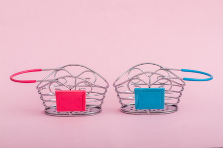 Miniature shopping baskets on pink backgroundの写真素材