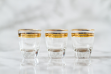 Vintage gold line gilded liquor glass cups on marbleの写真素材