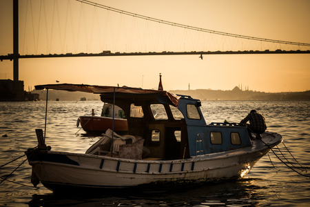 ISTANBUL, TURKEY - MAR 26, 2008: Fisherman rowing at sunset on a rowboatのeditorial素材
