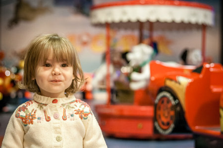 Cute baby girl smiling in frot of toy-land, natural lookの写真素材