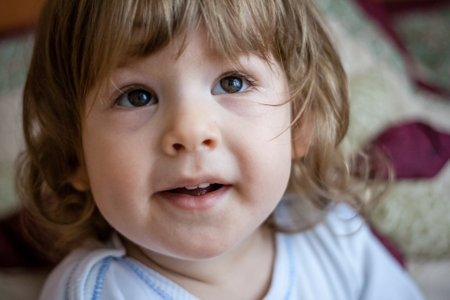 Cute baby girl looking in colorful bed, natural lookの写真素材