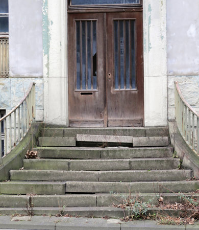 Broken stone staircase in front of a broken door.