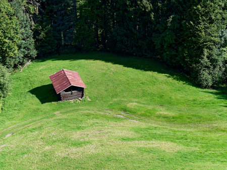 Picturesque view of a mountain meadow with a hut.の写真素材