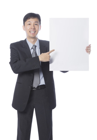 Businessman holding empty board, blank board for edited.Tall Man pointing at paper sheet with smile on his face.の写真素材