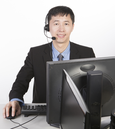 operator in black suit clicking mouse, white backgroundの写真素材