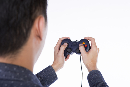 asian man playing games with black joystick, back view white background