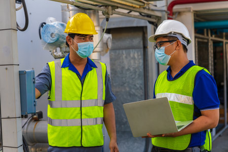 Two Asian Male engineering working at factory.