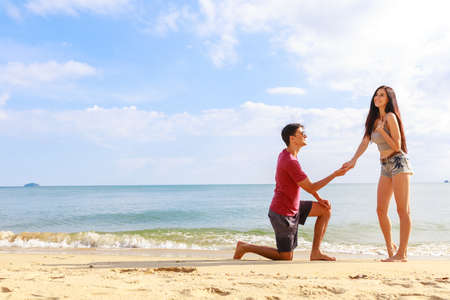A Male making a wedding porposal on the beach.の写真素材