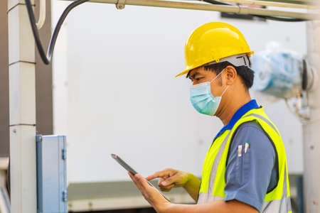 Engineer with safety helmet at the construction site typing on a digital tabletの写真素材
